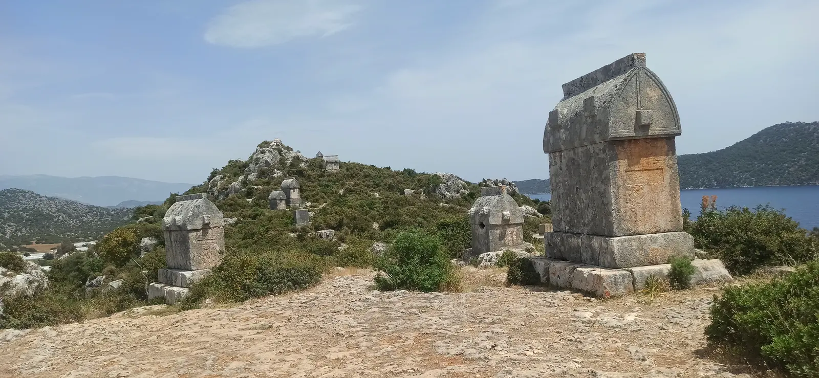 Ancient Lycian stone sarcophagi on a rocky hill above the sea