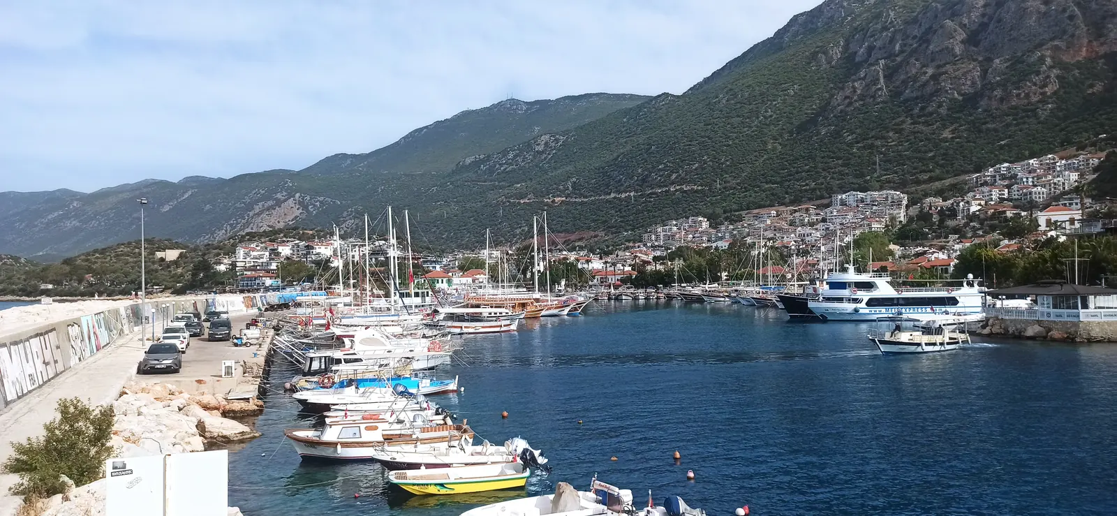 The harbour of Kaş with yachts and white houses climbing the hillside