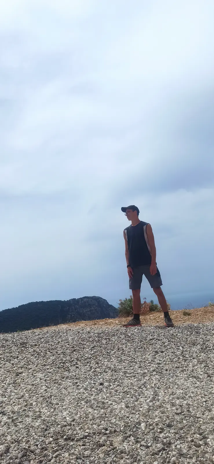 Andrii standing on a gravel ridge against a grey sky