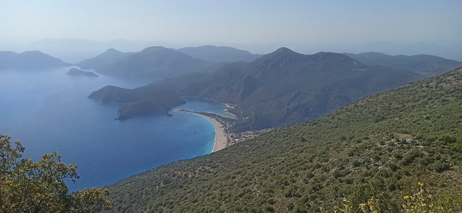 The blue lagoon and white sand spit of Ölüdeniz seen from a high slope