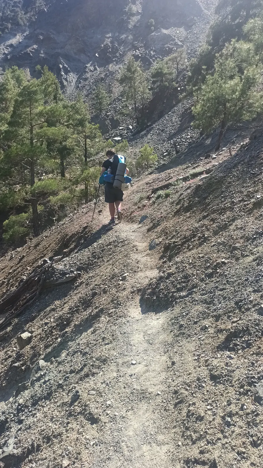 Yura on a narrow path across a steep scree slope