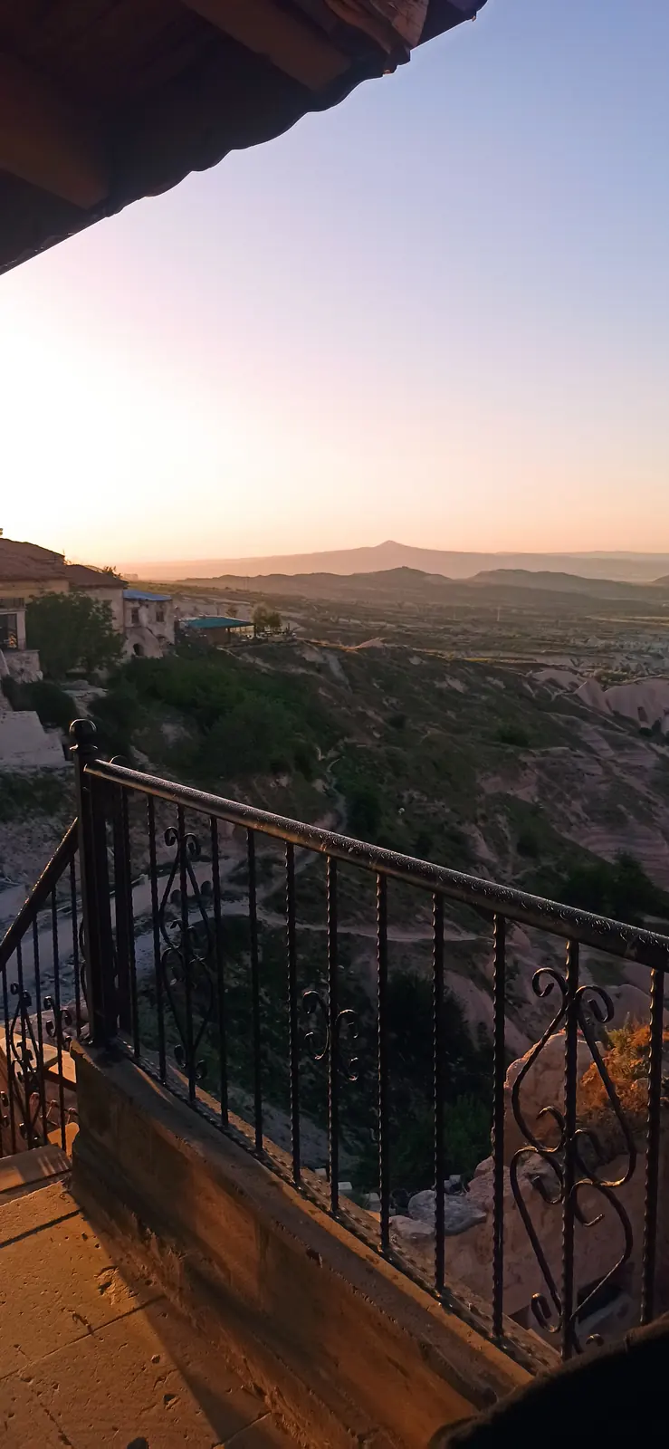 Sunset over rocky valleys seen from an iron balcony