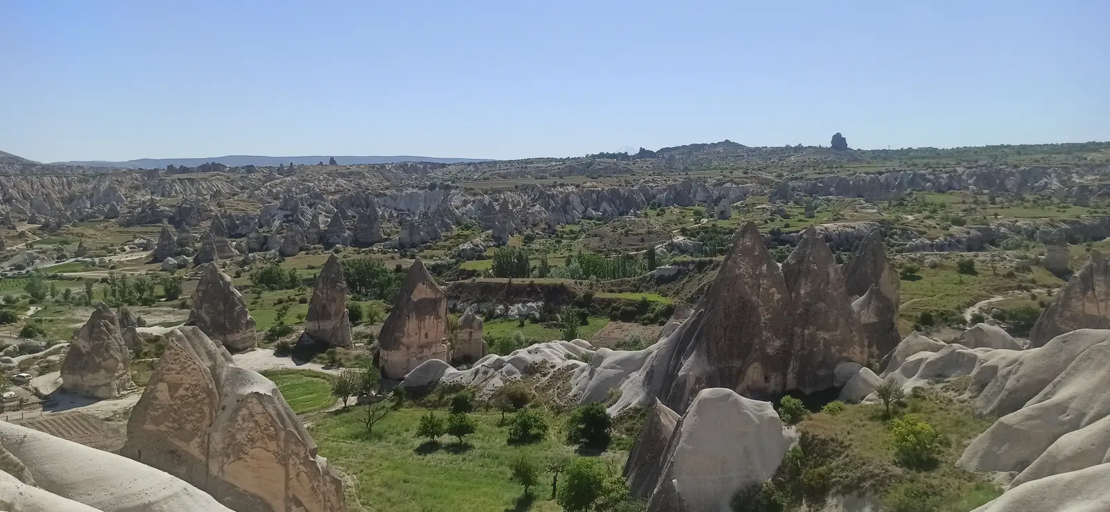 A valley full of rock cones and fairy chimneys among green fields